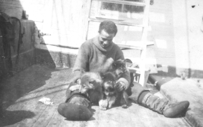 George Borup, on the deck of the Roosevelt, playing with puppies