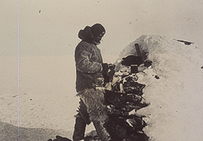 Donald Baxter MacMillan standing by a cairn 